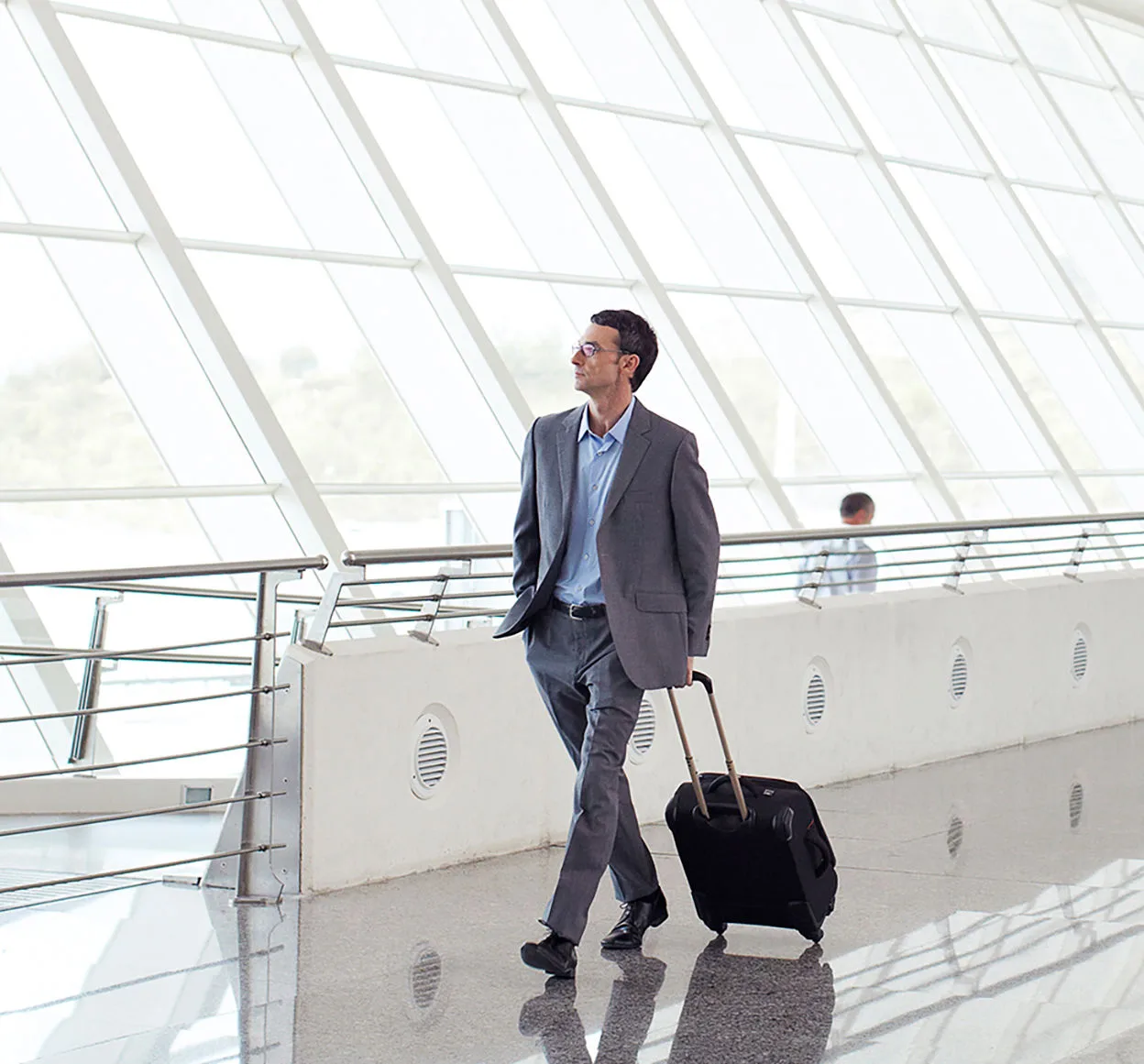 Businessman walking through airport with roller luggage