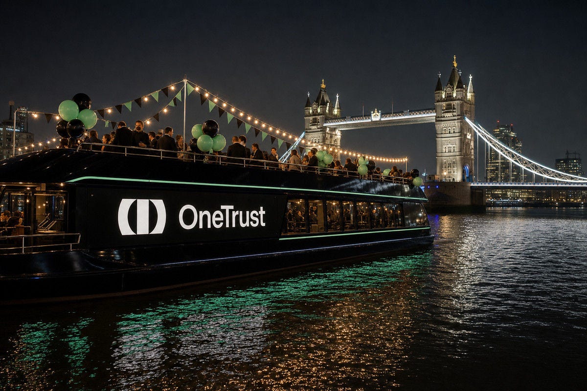 An OneTrust-branded boat decorated with balloons and string lights cruises past London’s Tower Bridge at night.